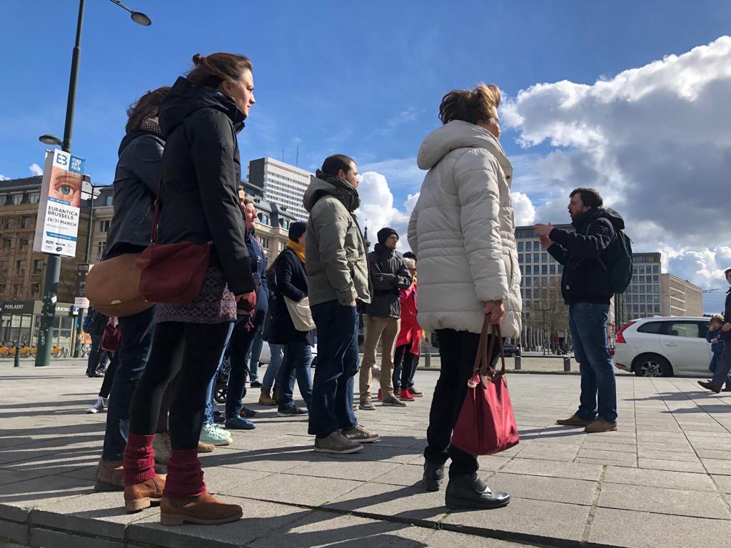 Stop van de groep aan het Poelaertplein en uitleg over de geschiedenis van de Brusselse Rechtbanken met Brussels By Foot